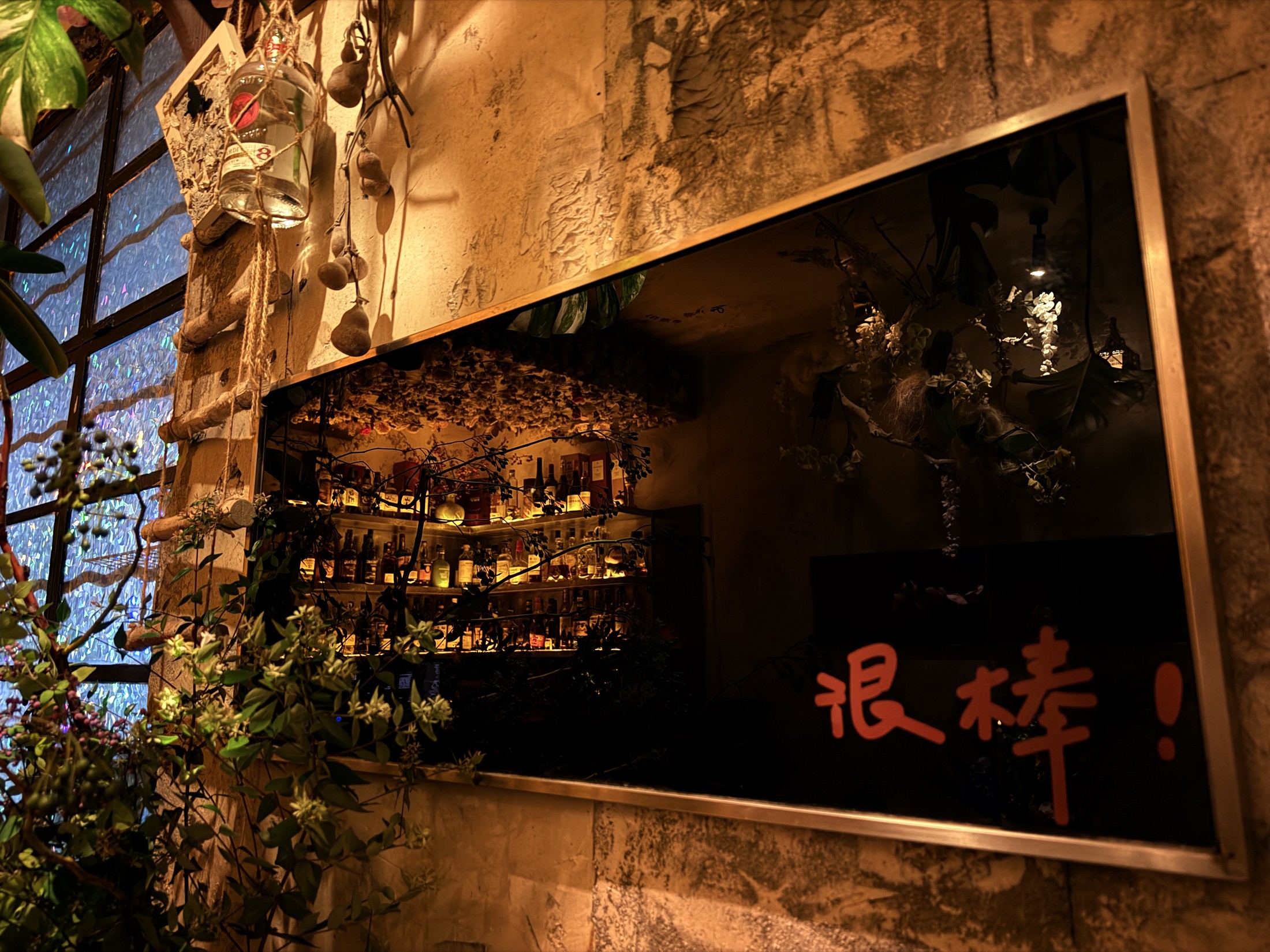 在竹酒吧镜面里的花园与吧台