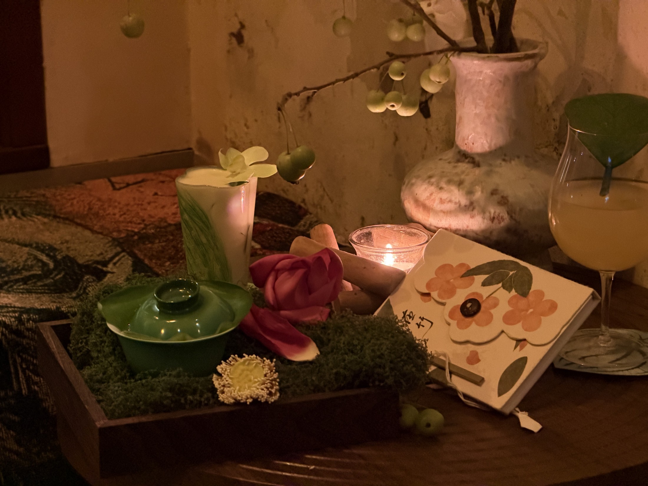 花艺、烛光与两杯鸡尾酒组成的花园桌面